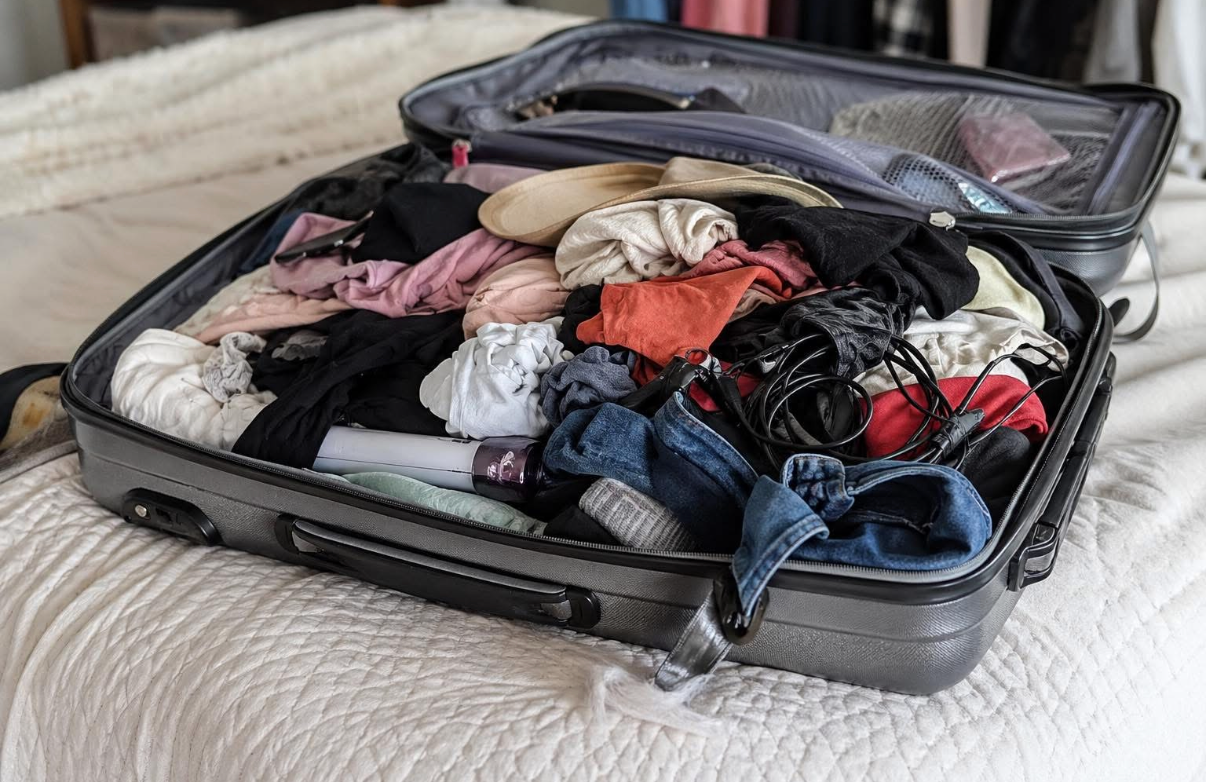 Messy suitcase with clothes scattered in small cabin space